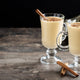 two hot cinnamon milks in a tall glass on a wooden table. Photo byChandlervid85 on Freepik 
