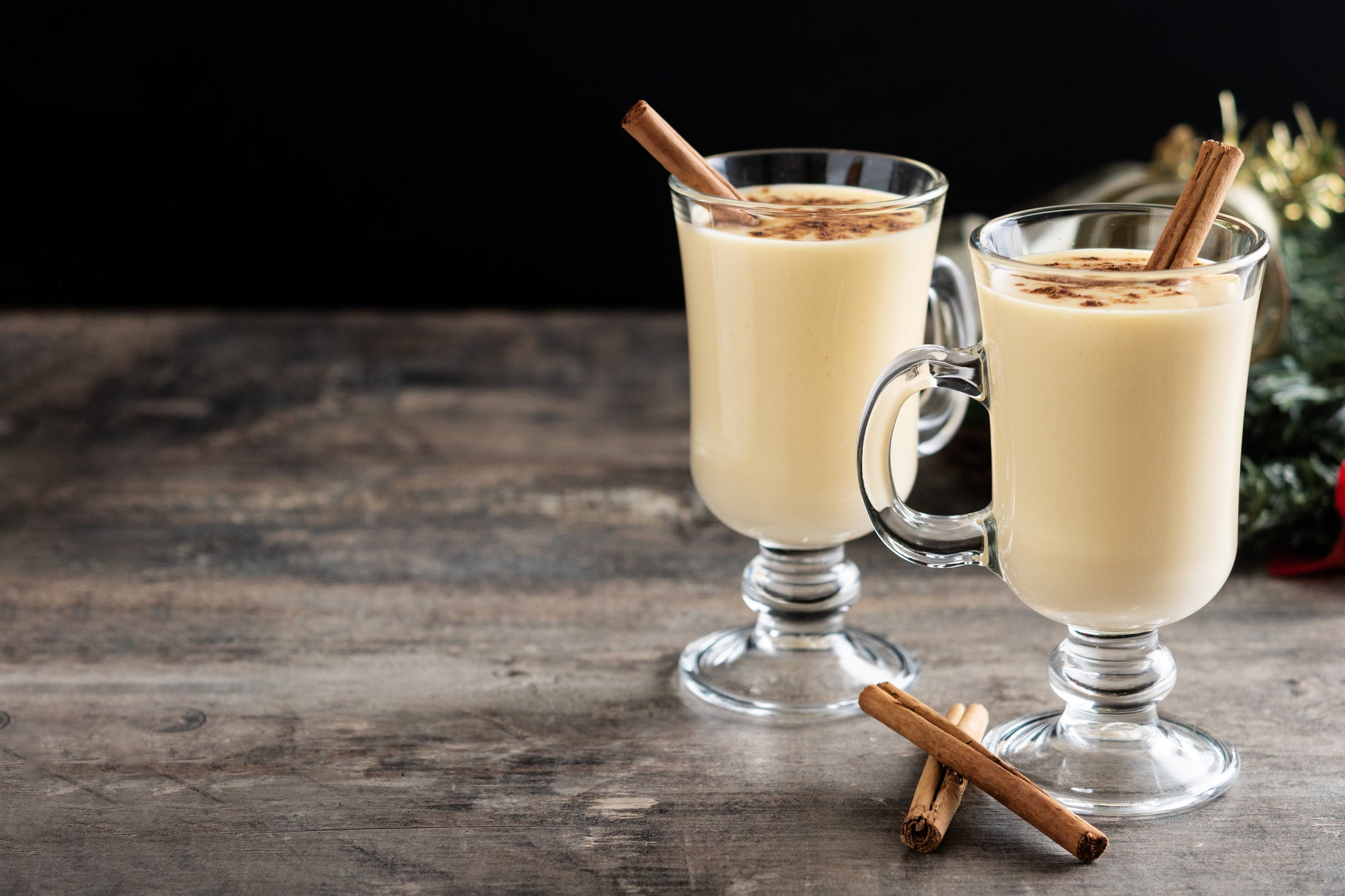 two hot cinnamon milks in a tall glass on a wooden table. Photo byChandlervid85 on Freepik 