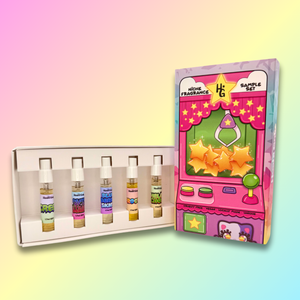 Set of samples with colorful labels next to a pink toy machine-themed box on a gradient background