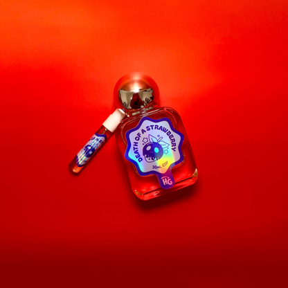 A small bottle of 'death of a Strawberry' perfume with a silver cap and a matching spray vial, set against a vibrant red gradient background.