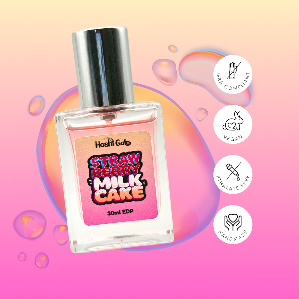 Perfume bottle labeled 'Strawberry Milk Cake' with vegan, IFRA compliant, Pthalate free, and handmade labels on a pink and orange gradient background.