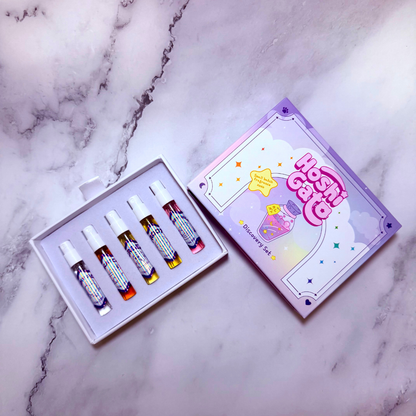 Hoshi Gato Discovery Set perfume spray vials in a decorative purple box, displayed on a light gray marble surface.